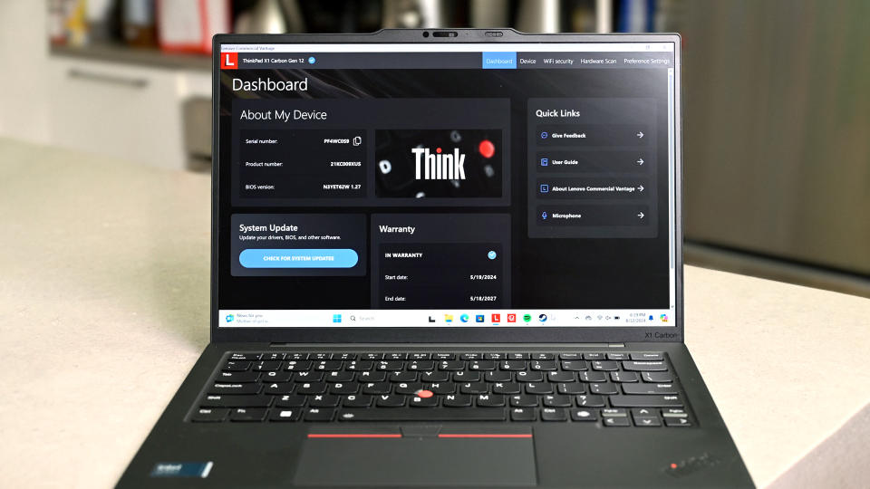 Το Lenovo ThinkPad X1 Carbon (12ης γενιάς) με την οθόνη και το πληκτρολόγιο στραμμένο προς την κάμερα. Στην οθόνη του βρίσκεται ο πίνακας ελέγχου Think της Lenovo που δείχνει πληροφορίες για τη συσκευή, συμπεριλαμβανομένης της ενημέρωσης συστήματος και της εγγύησης.