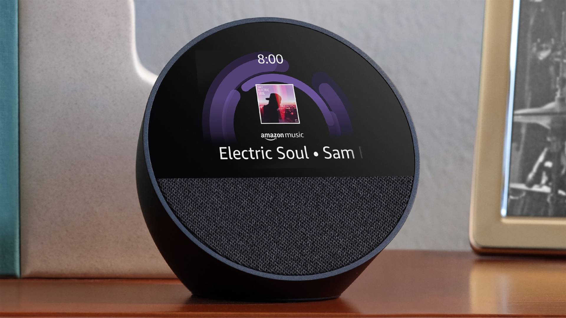 Black Echo Spot (2024) τοποθετημένο σε τραπέζι με εξώφυλλο άλμπουμ και ώρα στην οθόνη.