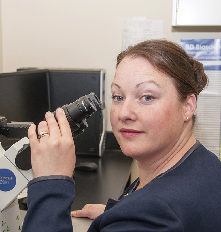 Deanna Gibson pictured in her office while using a microscope